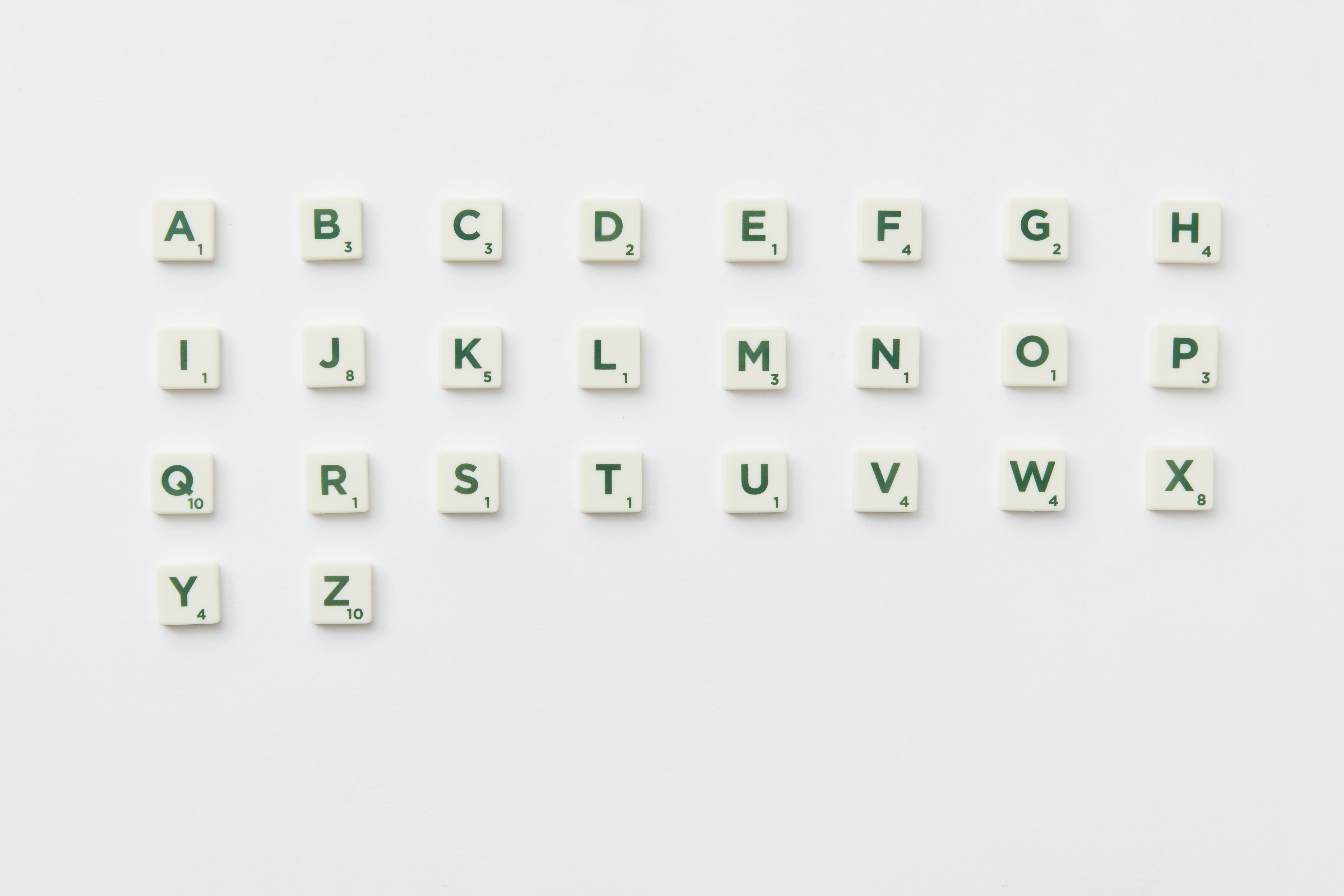 Scrabble tiles arranged alphabetically on a clean white background in a top view layout.