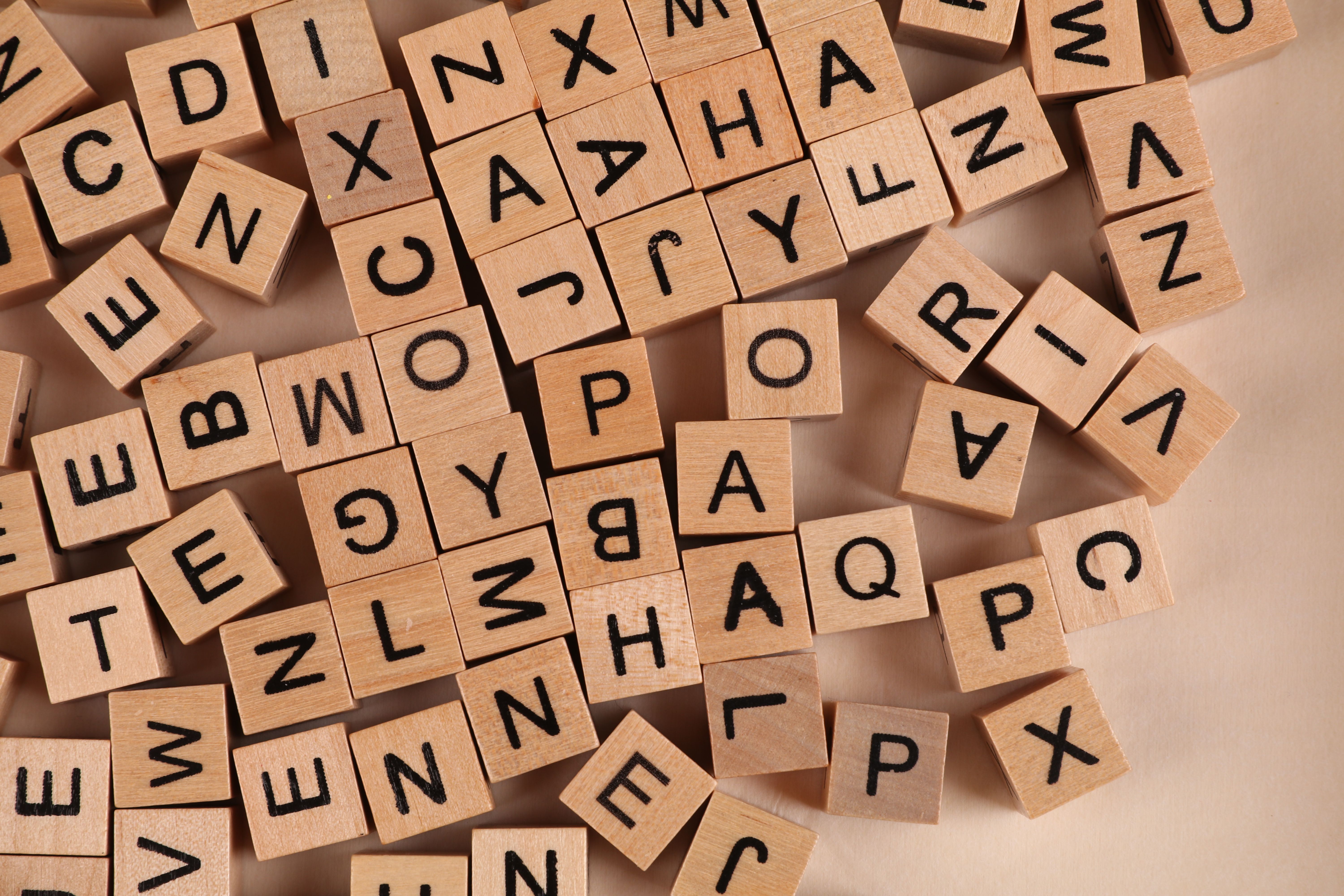Close-up of scattered wooden alphabet blocks, ideal for educational and playful themes.