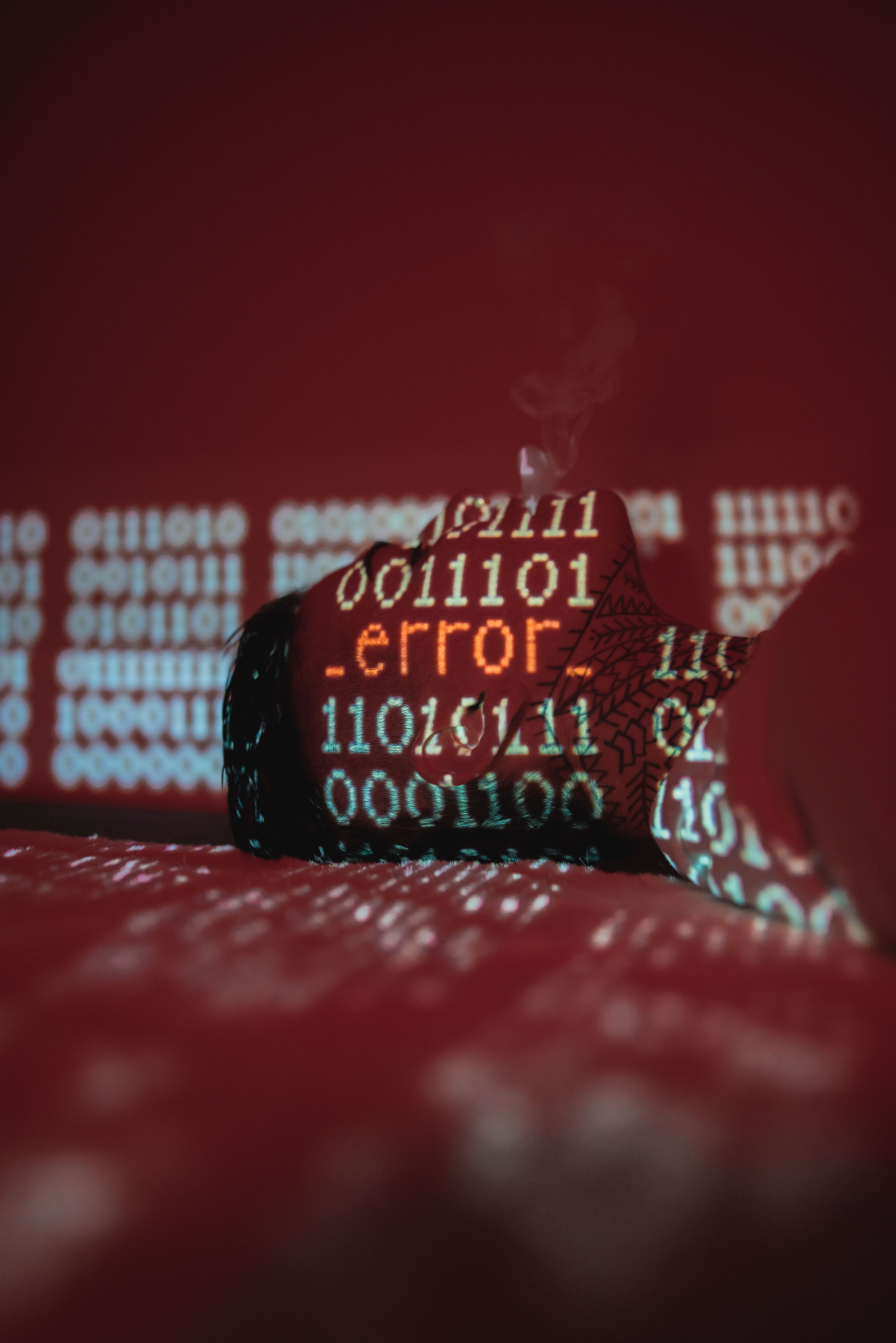 A conceptual image showing error code projected on binary data with smoke.